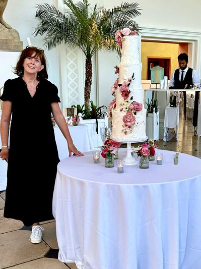 Anne-Marie setting up a five tier wedding cake with sugar flowers at Kew Gardens, Richmond