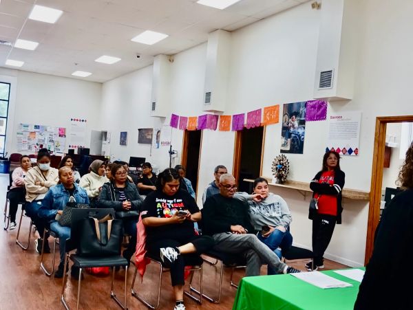 A diverse group attending a community meeting in a bright room.