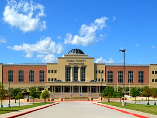 Collin County Courthouse building under a bright blue sky.