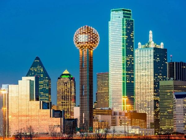 Dallas skyline at dusk with illuminated buildings and Reunion Tower.