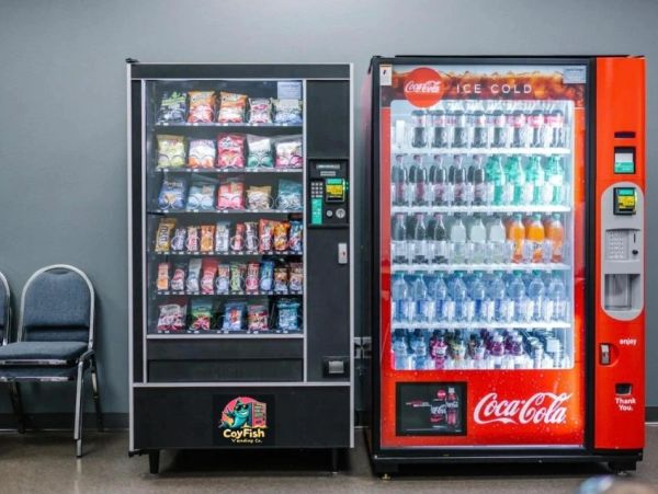 Two vending machines—one for snacks and one for Coca-Cola beverages.