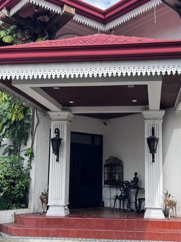 Front porch with red roof, white pillars, and decorative lanterns.