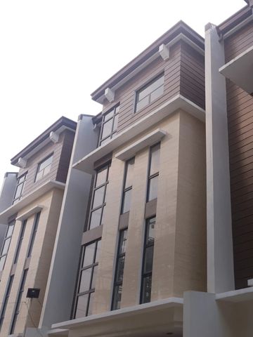 Modern multi-story building with large windows and beige and brown exterior.