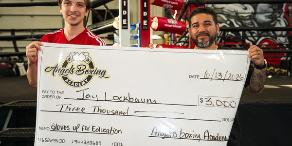 Two men holding a large $3,000 check from Angels Boxing Academy.
