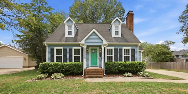 Blue house with green door and front yard.