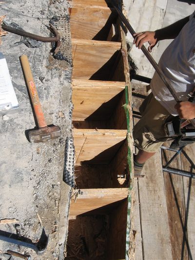 Worker using wooden molds for concrete.