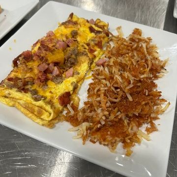 Two egg omelet stuffed with sausage, ham, bacon and cheese blends with a side of hashbrowns. 