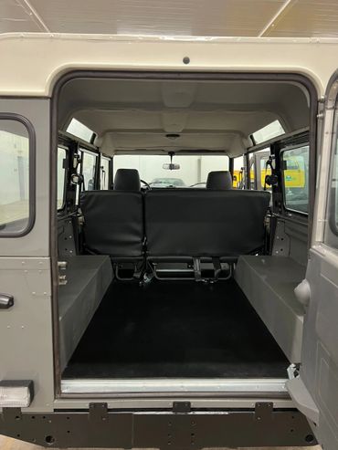 1991 Land Rover Defender 110 rear cargo compartment with side-facing rear seats.