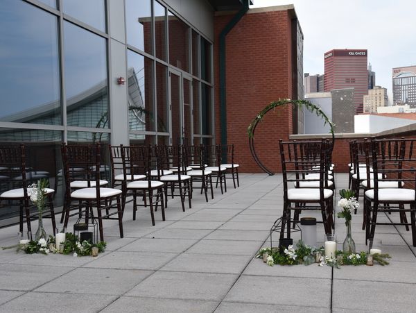 A detail photo of a small and intimate wedding set-up. There are a few chairs and flowers added.