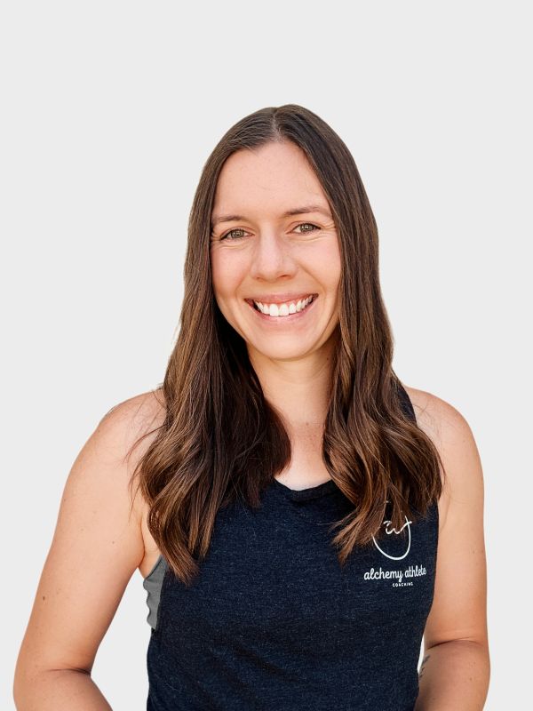 Smiling woman with long brown hair in a black tank top.