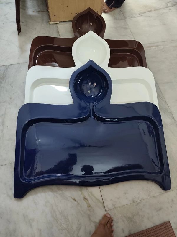 Stacked plastic trays in blue, white, and brown on a tiled floor.