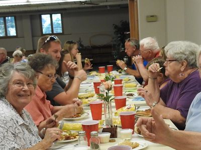 Group enjoying a meal together at a long table.