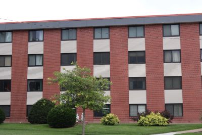 A red brick and white panel apartment building.