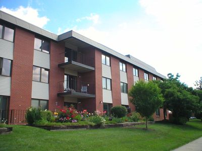 Three-story brick apartment building with greenery.