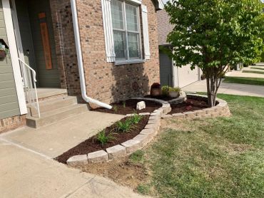 Well-maintained front yard with stone garden edging.