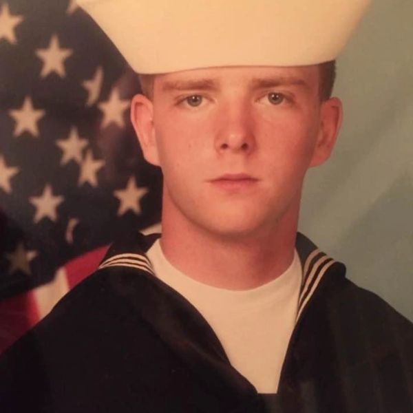 Dan Powell dressed in a United States Navy Dress Blues Uniform. 