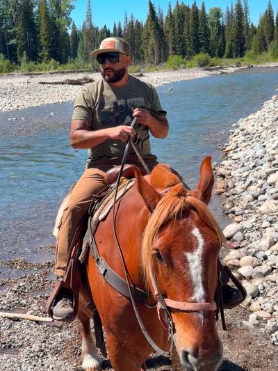 Samuel with Garnica's Concrete Construction riding a horse in the Wyoming wilderness