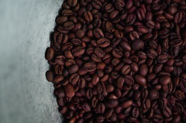 Freshly roasted coffee in a steel bowl.