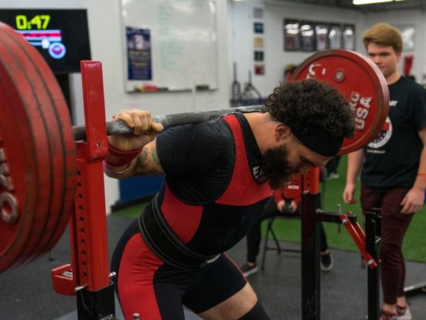 Man preparing for a heavy squat lift in a gym.