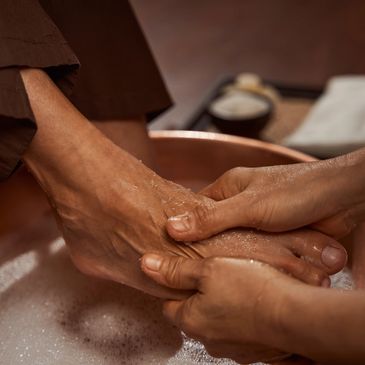 A person receiving a foot massage with water.