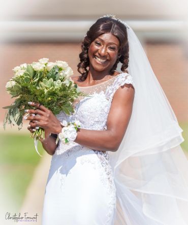 Smiling bride holding bouquet on wedding day.
