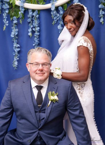Wedding photo of a couple with blue floral background.