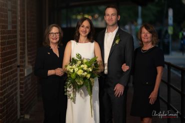 Bride and groom with two women in formal attire.