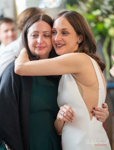 Two women hugging warmly indoors.