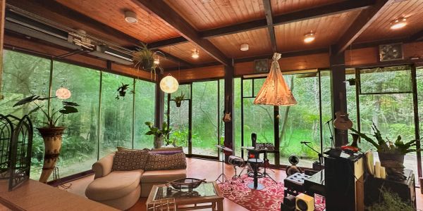 Cozy living room with large windows and forest view.