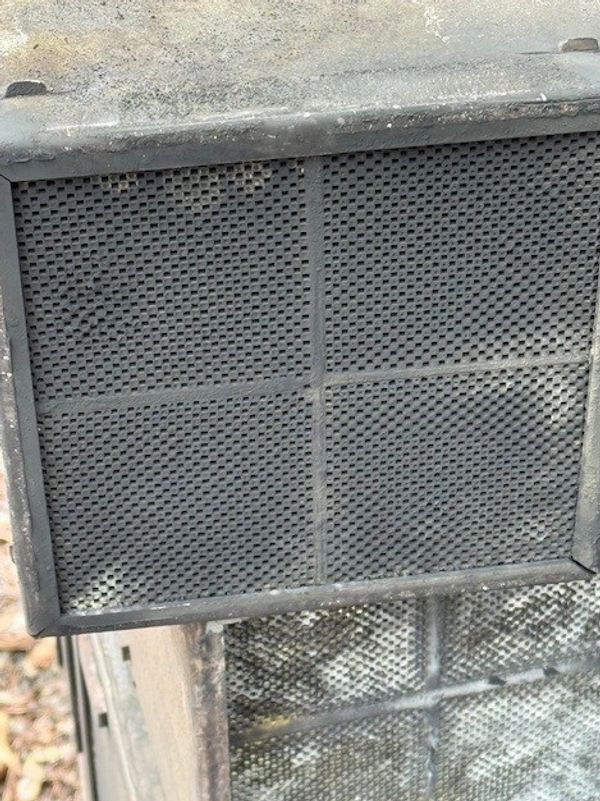 Close-up of a dirty metal mesh screen.