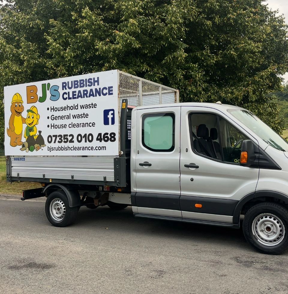 Silver truck with a sign for BJ's Rubbish Clearance services.
