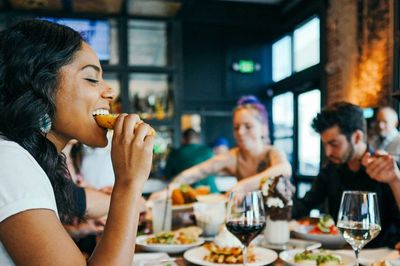Friends enjoying a diverse meal together at a lively restaurant.