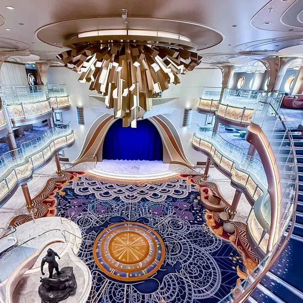 Luxurious multi-level theater with ornate chandelier and intricate carpet design.
