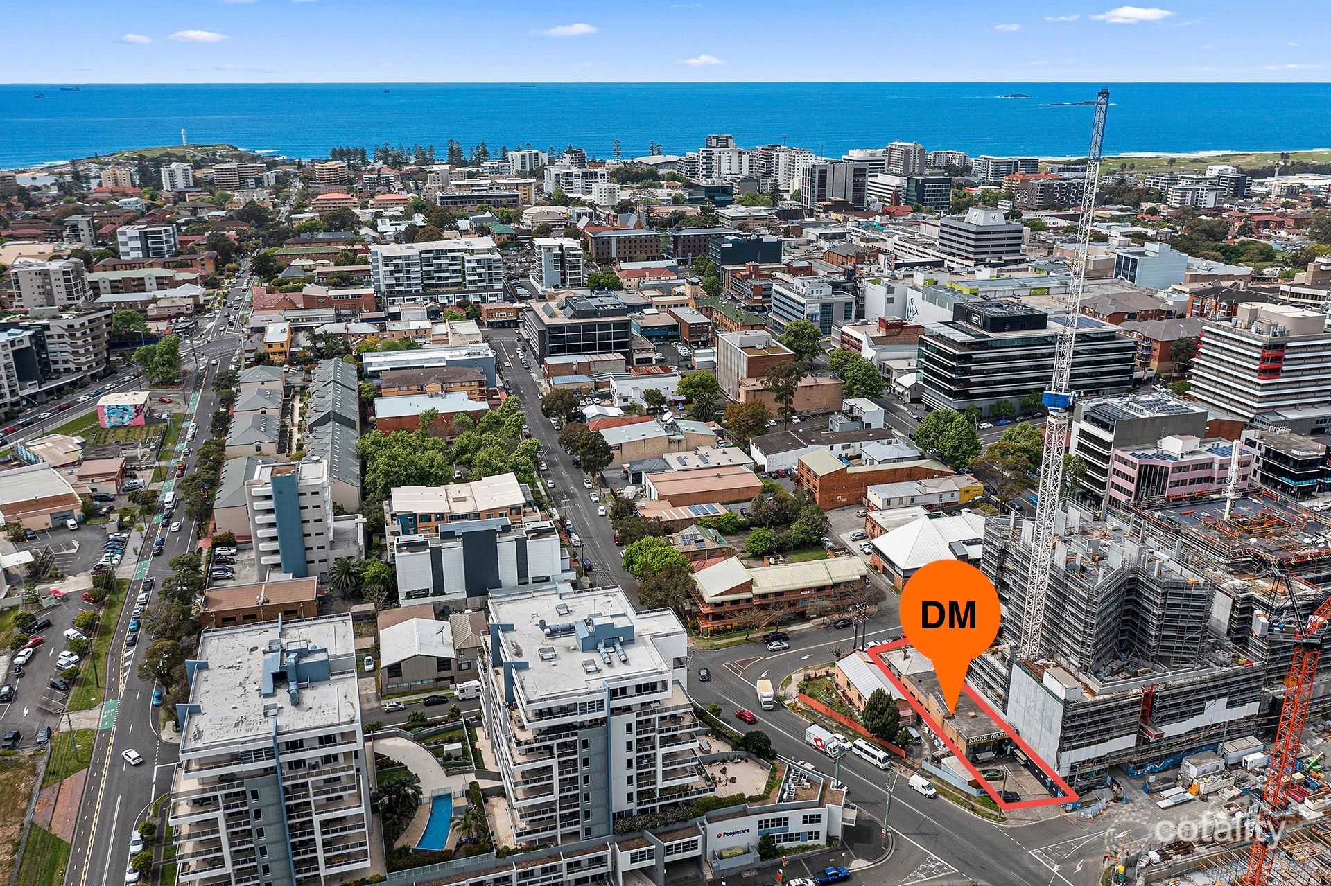 Aerial view of a coastal city with buildings and the ocean in the background.