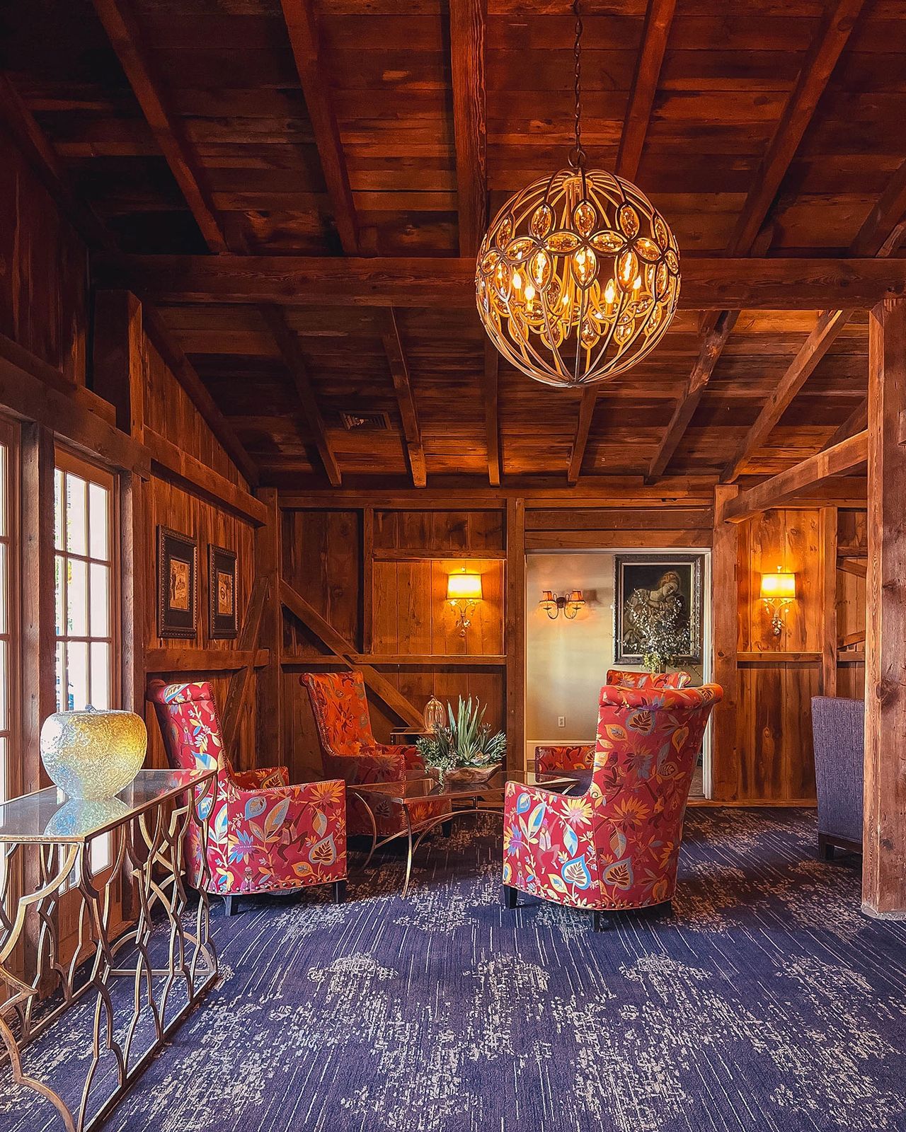 Step inside The Inn at Leola Village, a beautifully restored historic inn in Lancaster County, Pennsylvania, where rustic charm meets luxurious comfort. This inviting lounge area, with its warm wooden beams, elegant lighting, and vibrant floral seating, offers a cozy and sophisticated ambiance. Whether you're here for a romantic getaway, a spa retreat, or a fine dining experience, The Inn at Leola Village provides a perfect blend of historic charm and modern elegance.