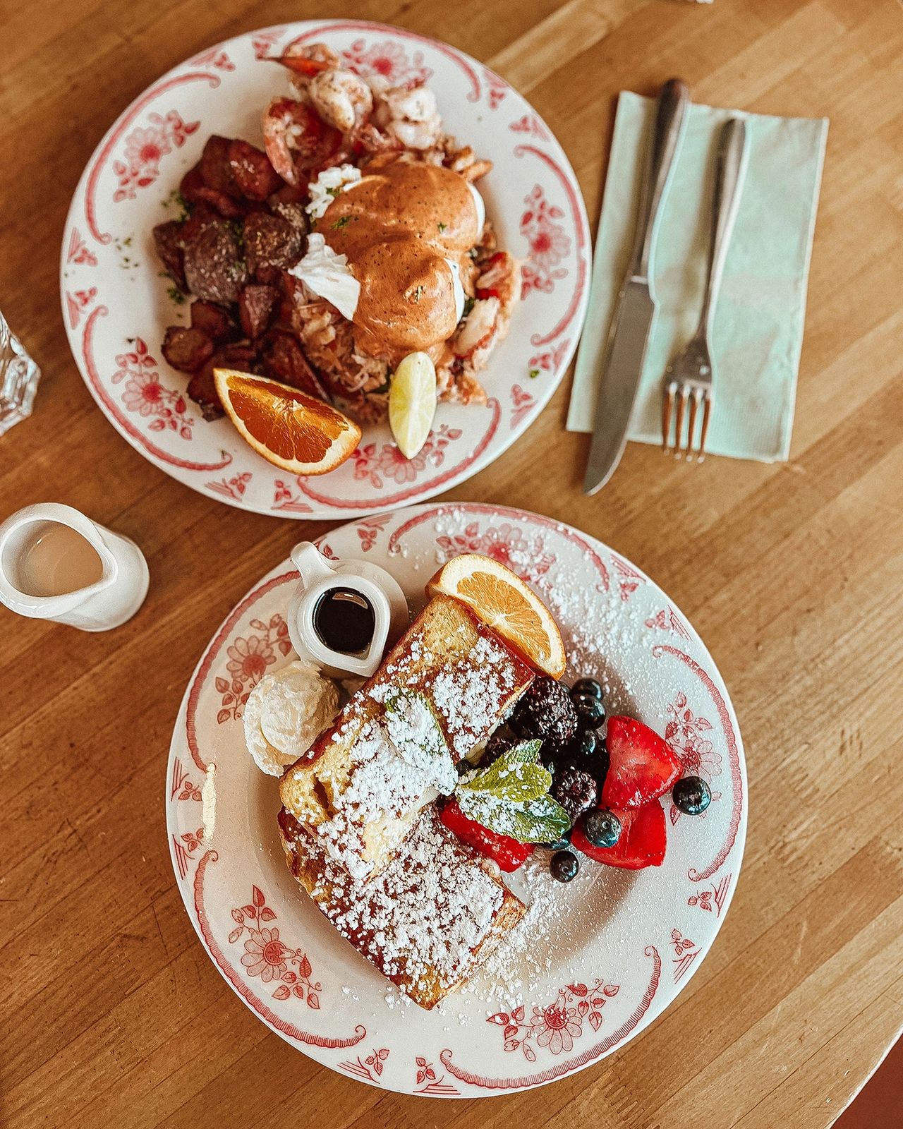 A mouthwatering brunch spread at Plain Jane in San Francisco, featuring lobster eggs benedict with roasted potatoes and fluffy French toast topped with powdered sugar and fresh berries. Known for its vibrant and cozy vibe, Plain Jane offers one of the best brunch experiences in the city with delicious, beautifully plated dishes.