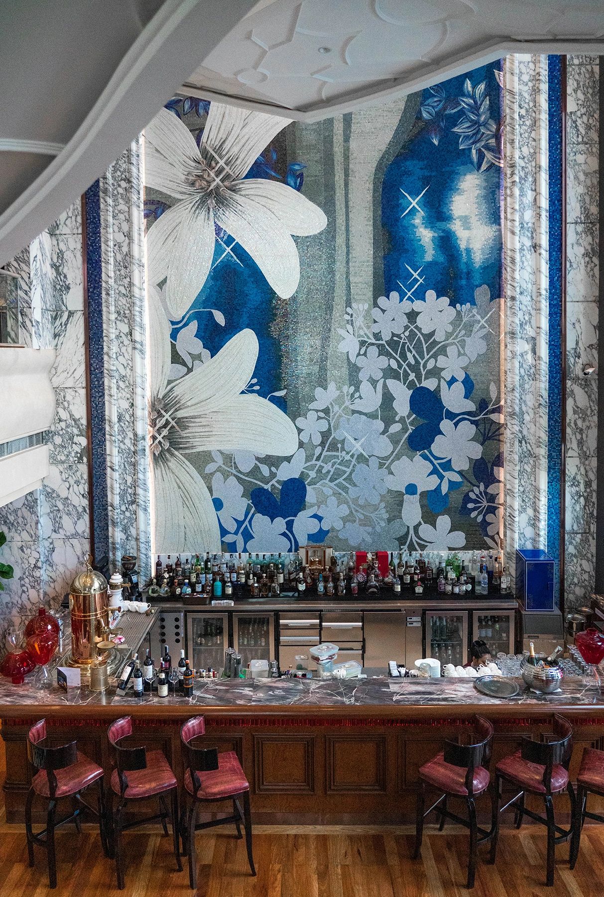 The Reverie Saigon's stunning bar featuring a blue floral mosaic wall and marble accents – a luxurious place to stay in this Ho Chi Minh City guide