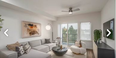 Modern living room with gray sectional sofa, round coffee table, and large window.