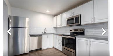 Modern kitchen with stainless steel appliances and white cabinetry.