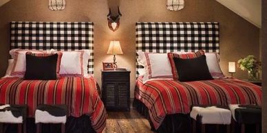 Cozy bedroom with matching checkered headboards and red striped bedding.