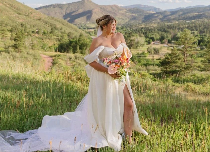 A radiant bride with flawless makeup atop a majestic mountain.