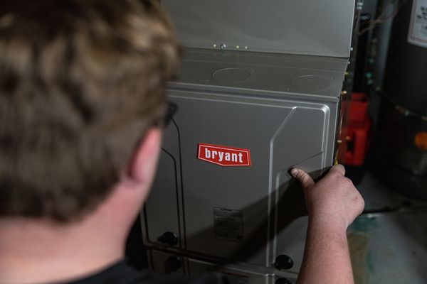 A technician making routine maintenance, repair, and inspection of a heating and cooling system.