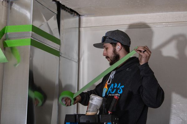 A technician making routine maintenance, repair, and inspection of a heating and cooling system.