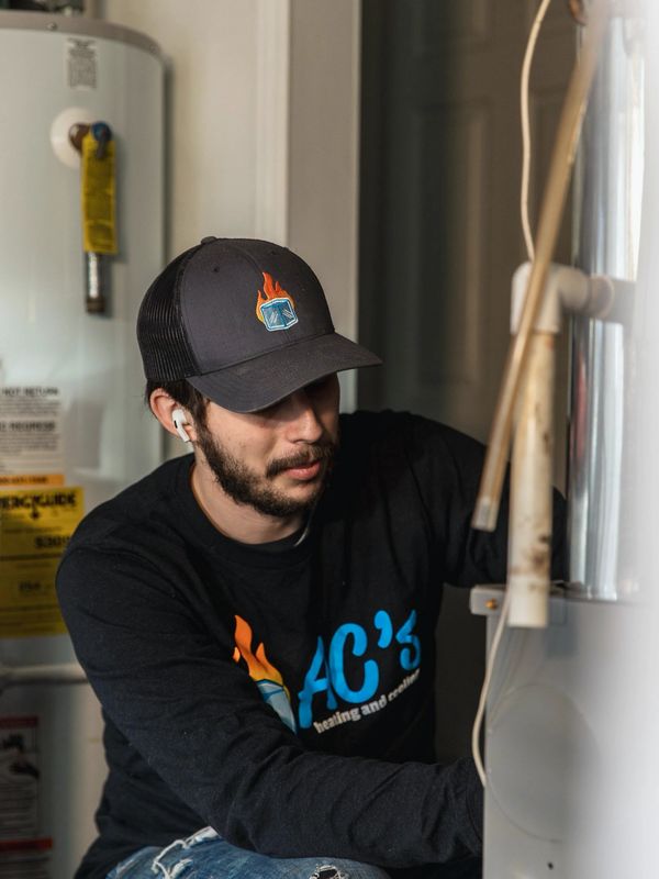 A technician making routine maintenance, repair, and inspection of a heating and cooling system.