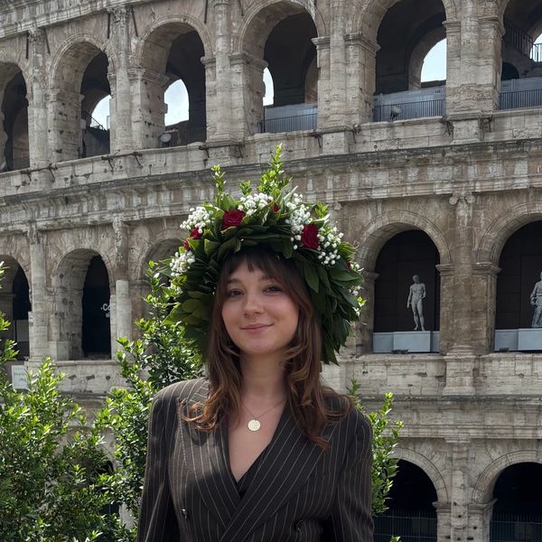 Young woman with floral crown in front of the Colosseum in Rome.