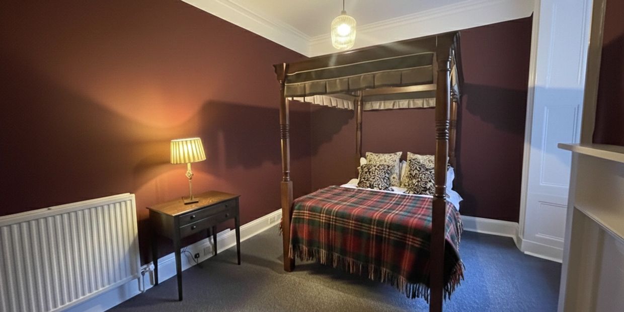 Cozy bedroom with a four-poster bed and warm lighting.