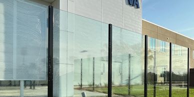 Modern glass panels with water flowing down in front of a building.