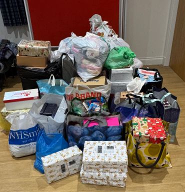 A large pile of gift bags and wrapped presents.