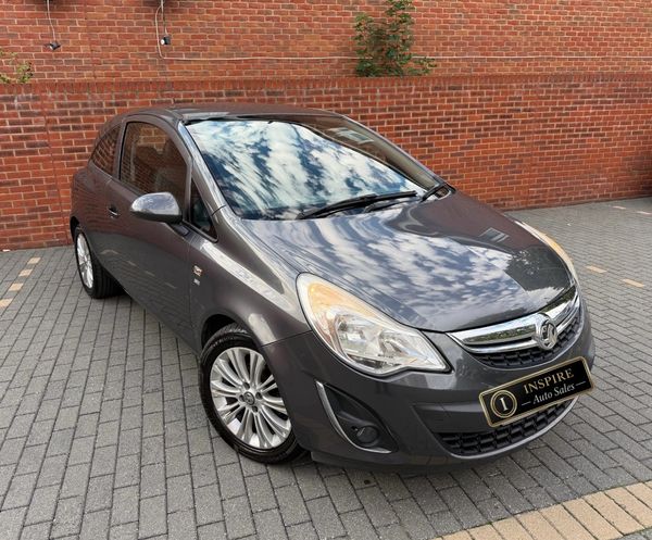 Gray Vauxhall hatchback parked on a brick driveway.