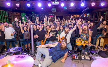 Energetic crowd enjoying a lively band performance at a vibrant venue.